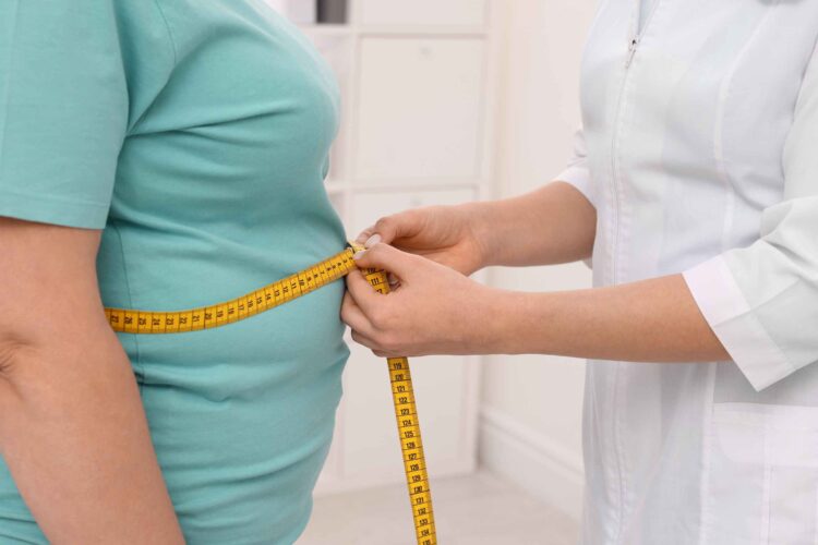 Man measuring his waist with a tape and checking blood pressure — representing metabolic syndrome